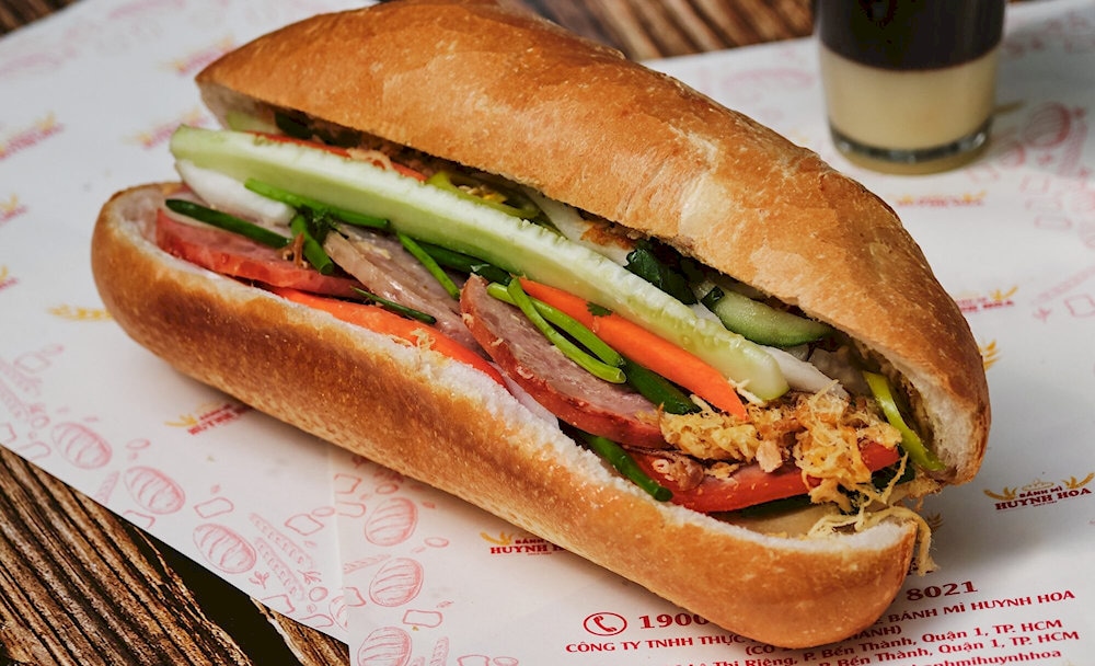“Banh mi Huynh Hoa” combines a crispy baguette, savory meats, rich pâté, fresh herbs, tangy pickles, and bold sauces into one perfect bite